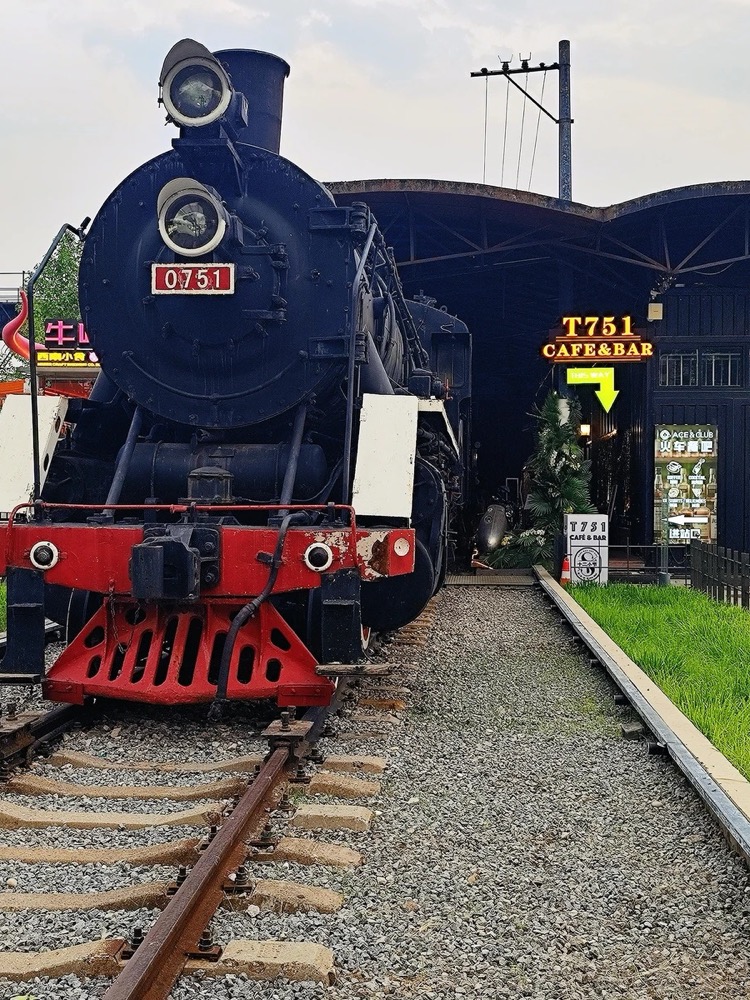 A preserved black steam locomotive on tracks in Beijing's 751 industrial area