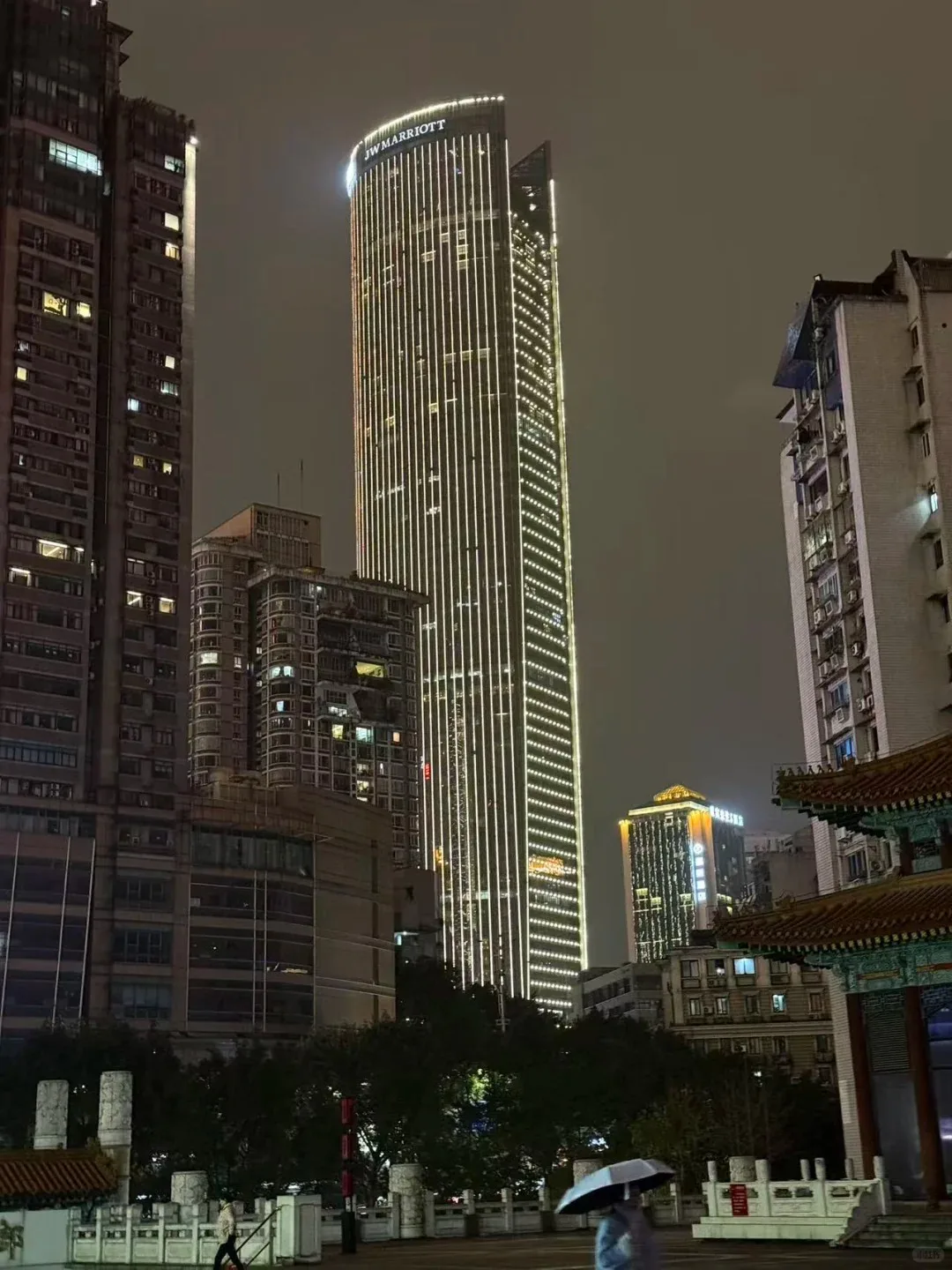 JW Marriott Hotel Chongqing tower illuminated at night near Jiefangbei