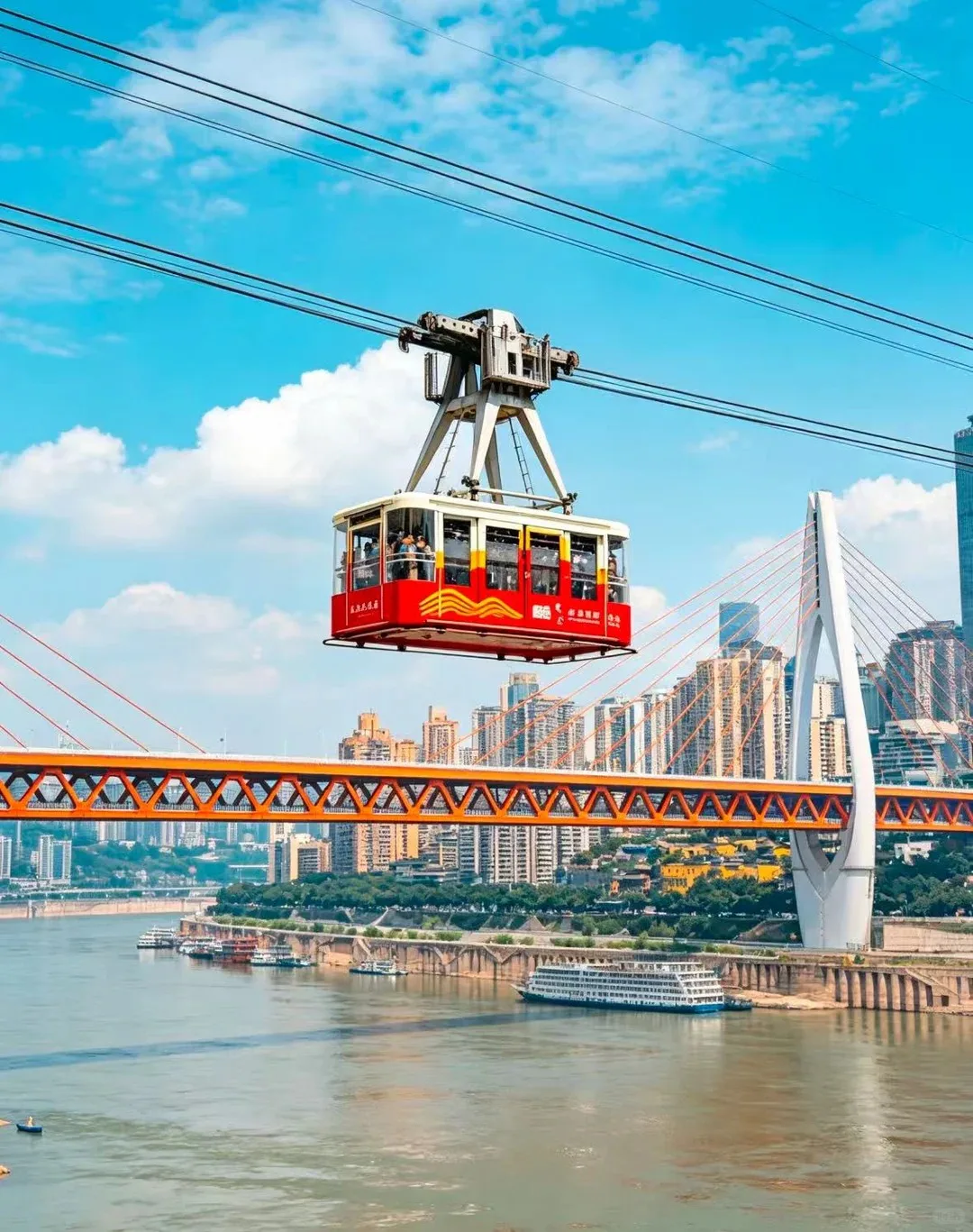 Red Yangtze River Cableway cabin above the river and Chongqing skyline