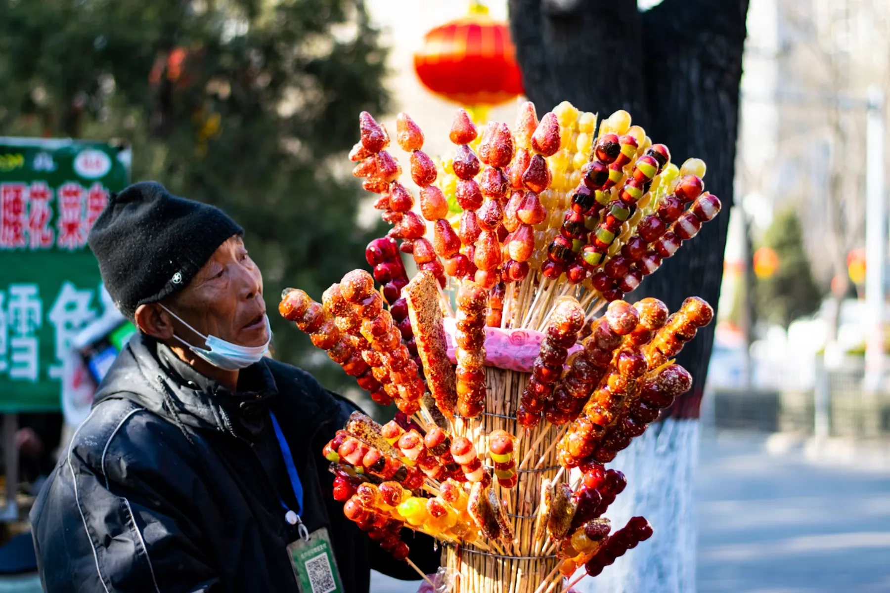 A street vendor displays bright tanghulu candied fruit skewers during winter in China.