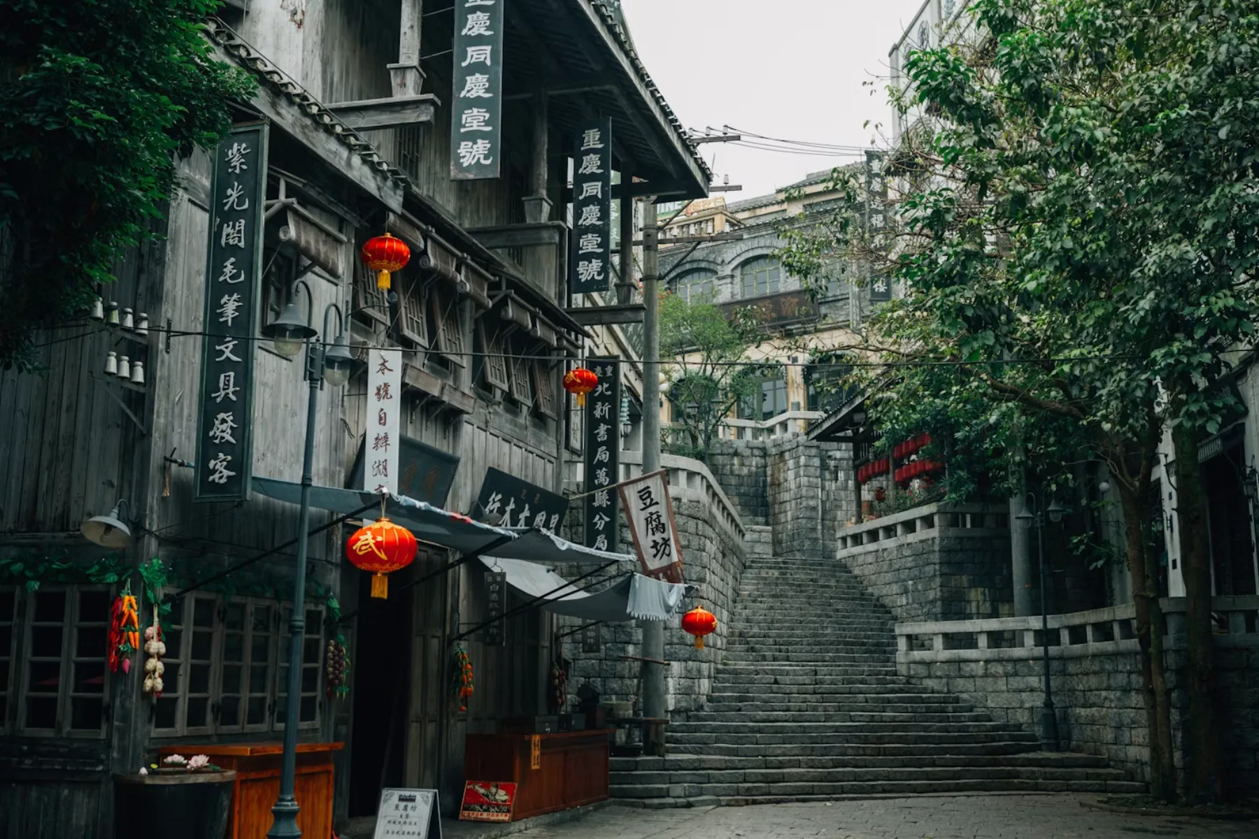 Stone steps, red lanterns and wooden shopfronts line a historic street in Chongqing, China.
