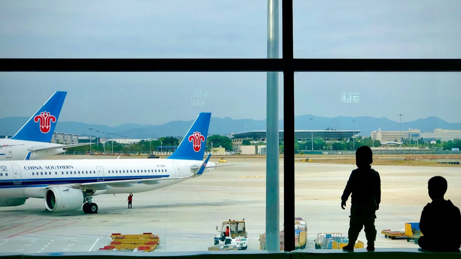 Aircraft and passengers seen through the terminal windows at Guangzhou Baiyun International Airport
