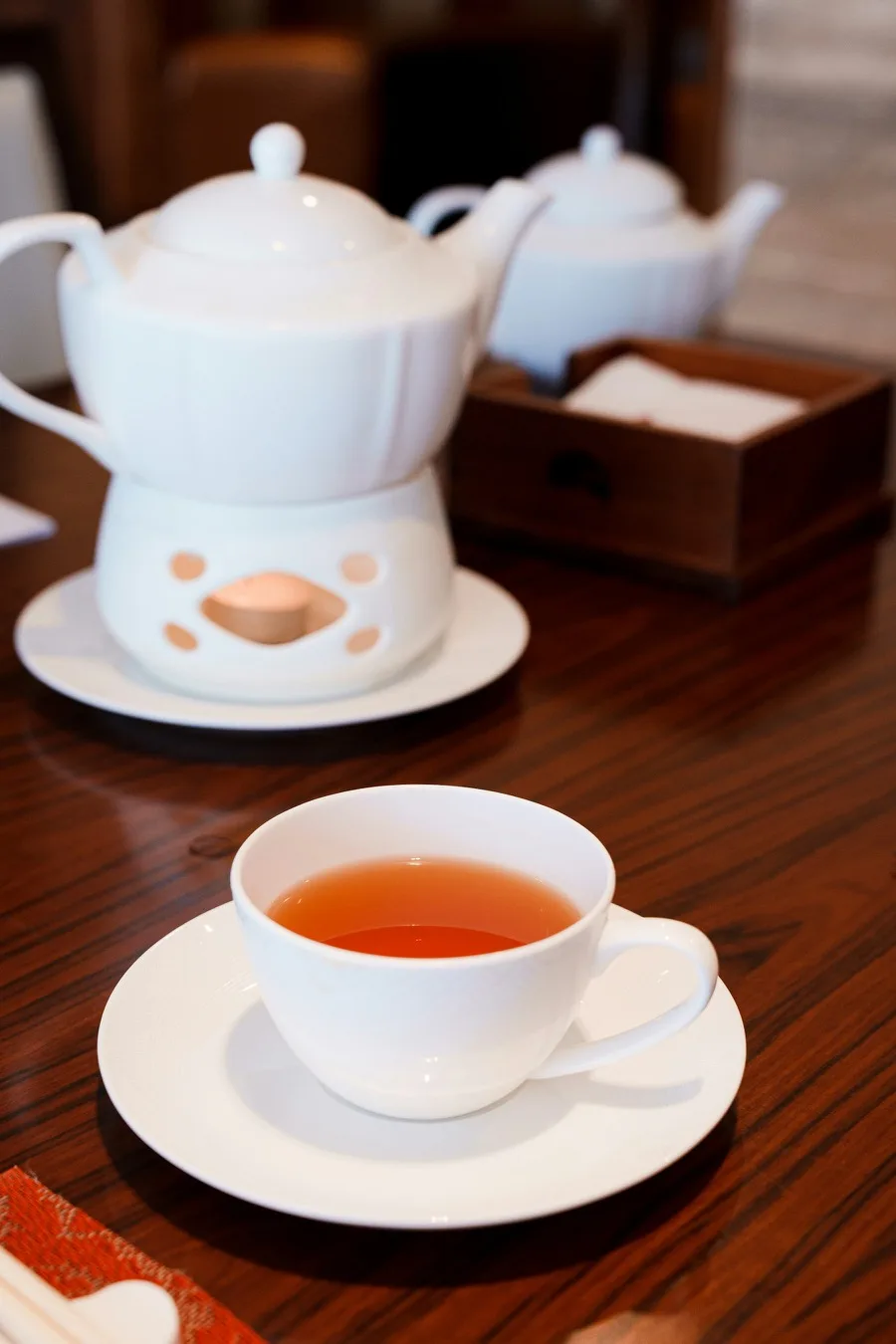A cup and pot of Chinese tea prepared on a wooden table in Guangzhou
