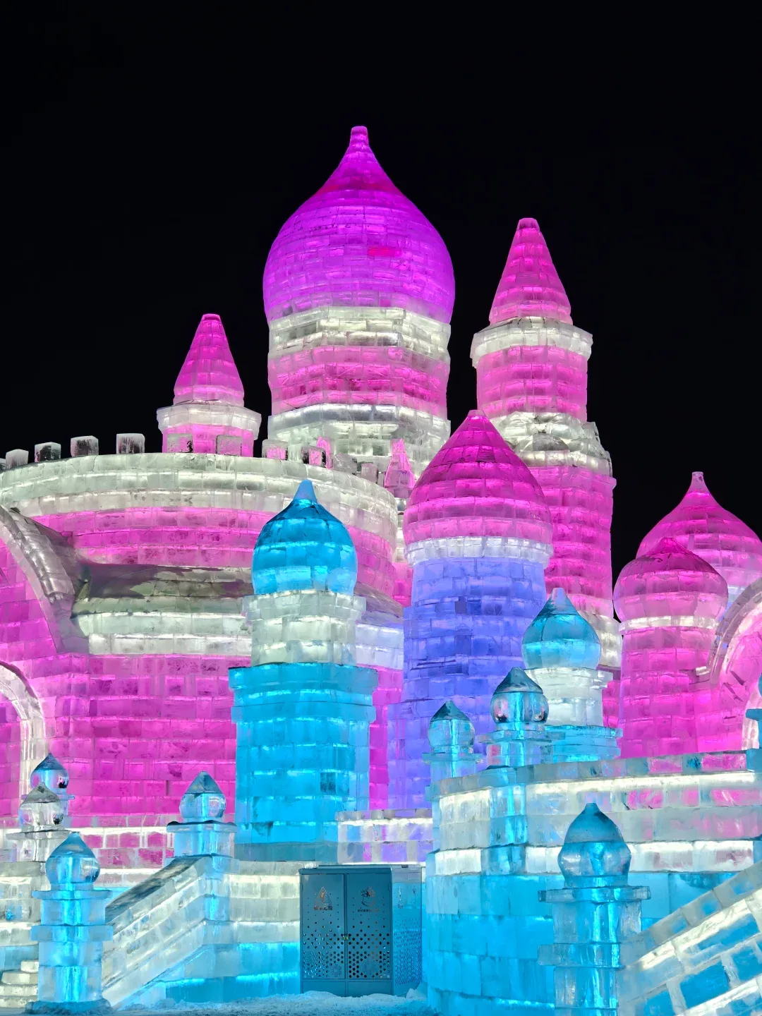 Illuminated pink and blue ice castle at Harbin Ice and Snow World