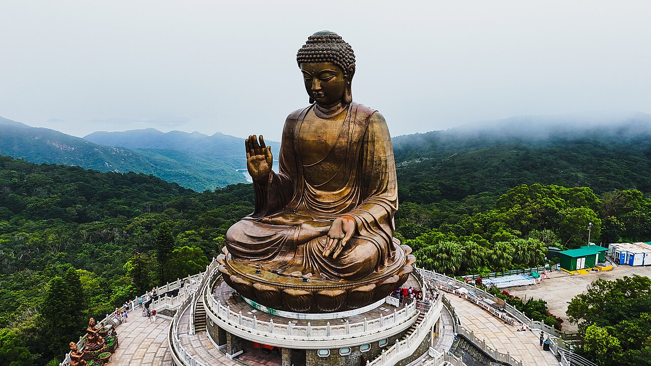 The seated bronze Tian Tan Buddha above the green hills of Lantau Island