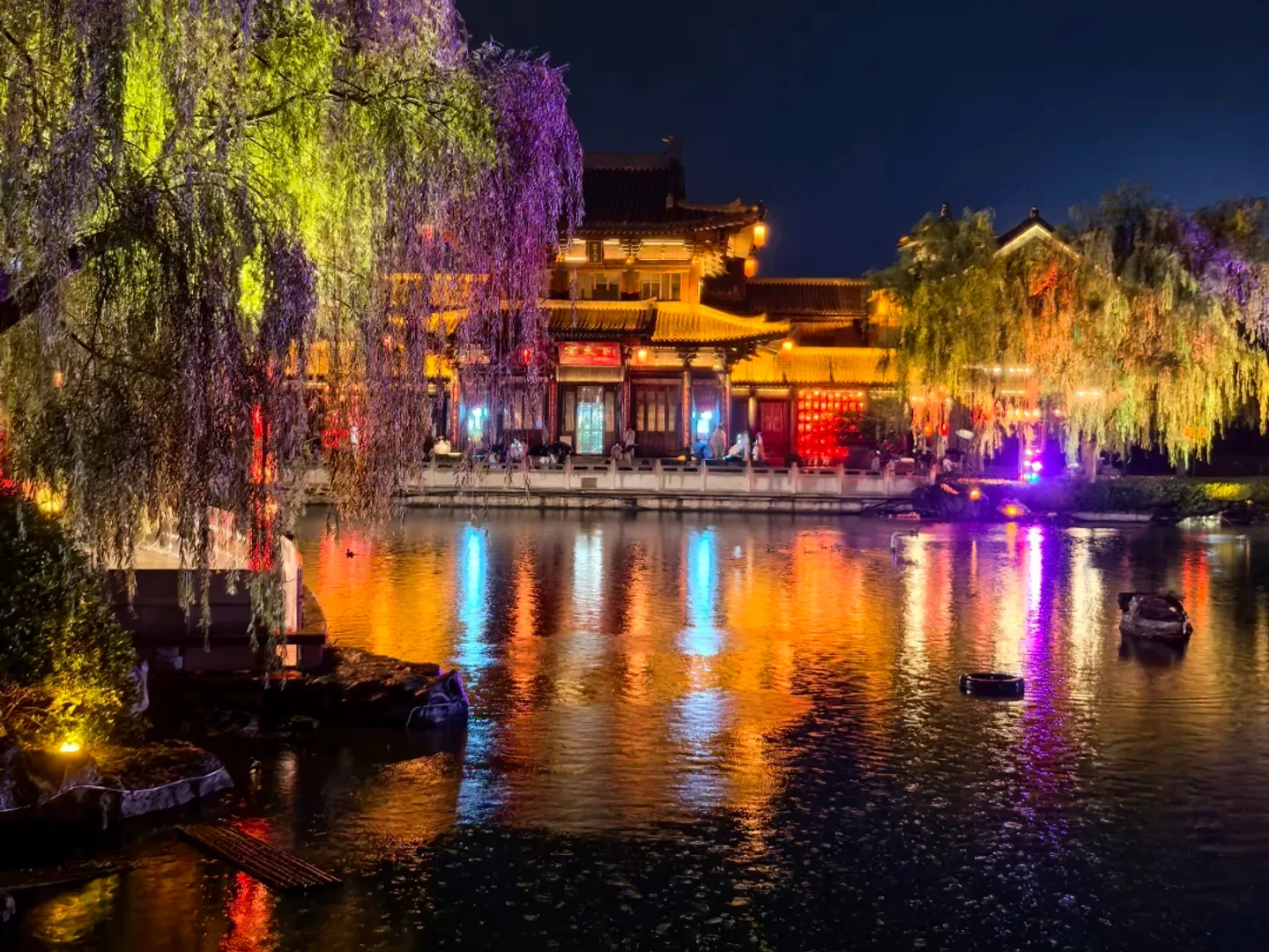 Traditional roofs and lantern-lit water in Luoyi Ancient City at night