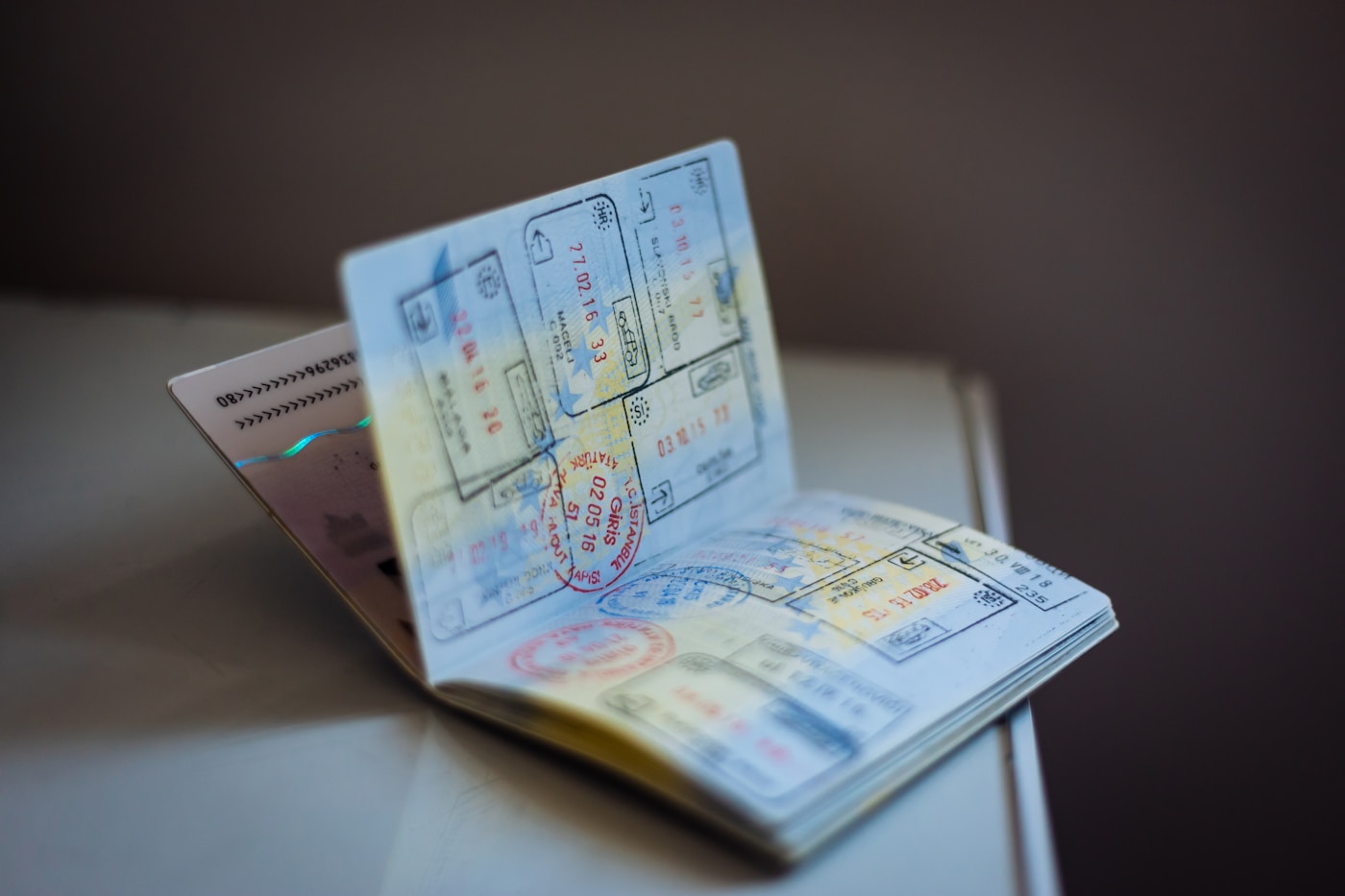 An open passport with travel stamps resting on a table