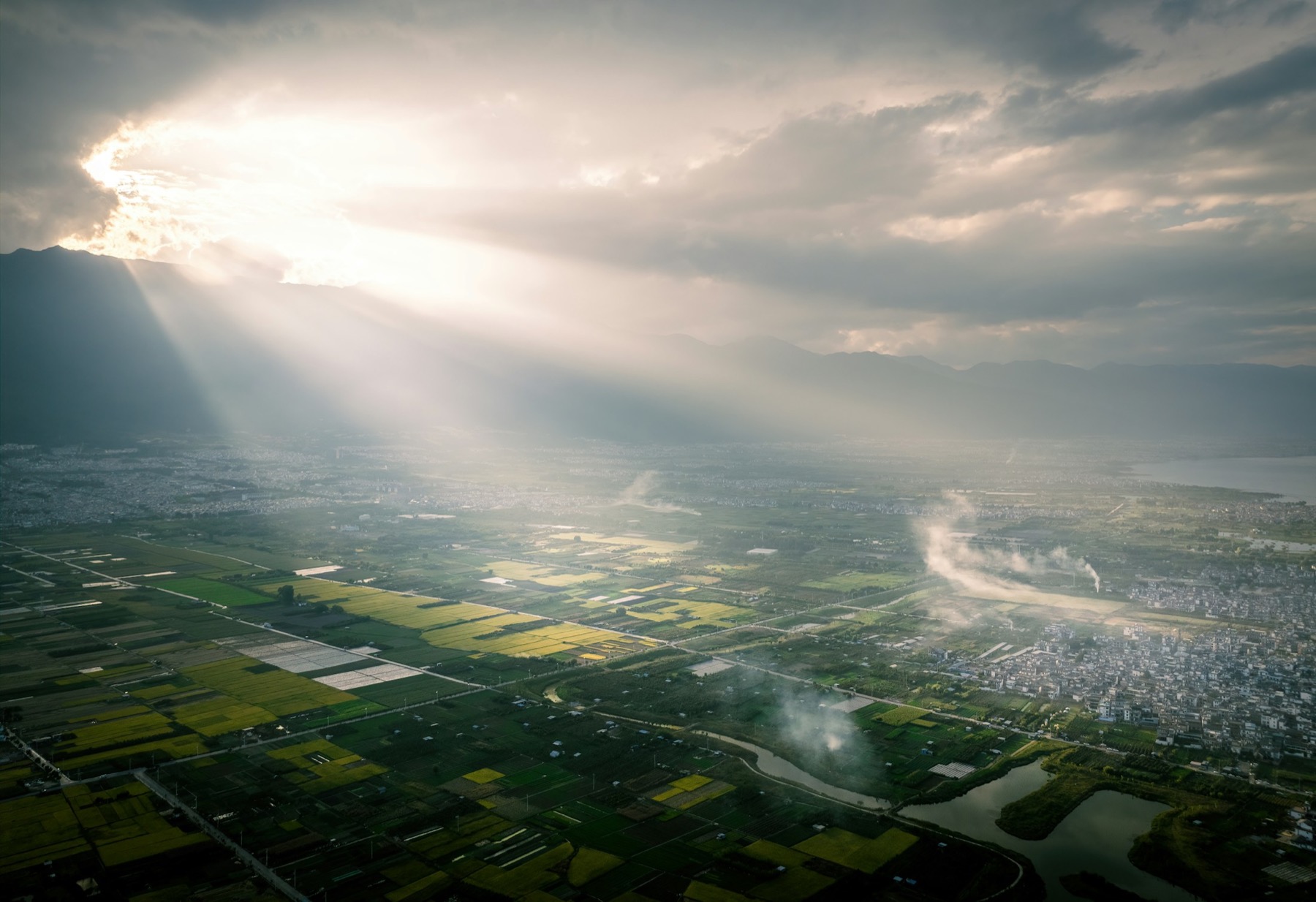 Sonnenlicht über Feldern und Bergen bei Dali in Yunnan