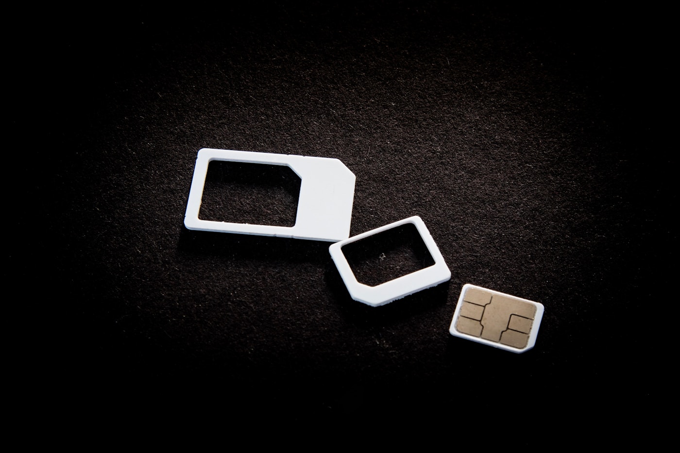 SIM cards and size adapters on a dark surface