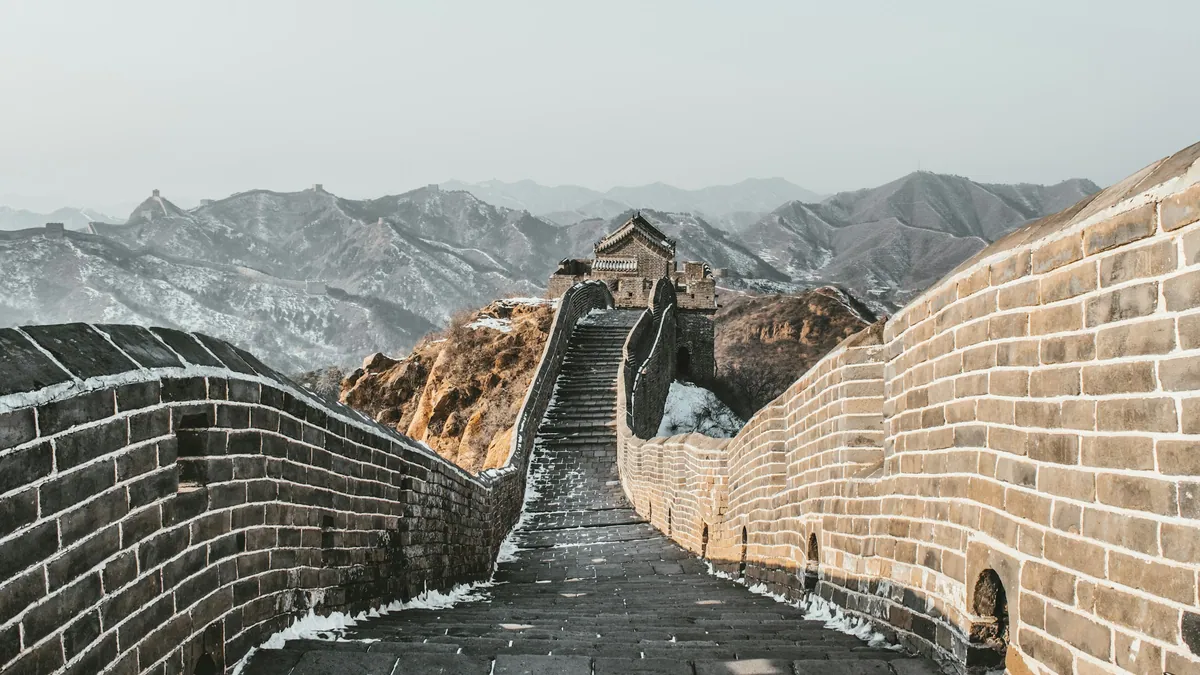 Stone walkway and watchtowers on the Great Wall with mountain ridges in the distance