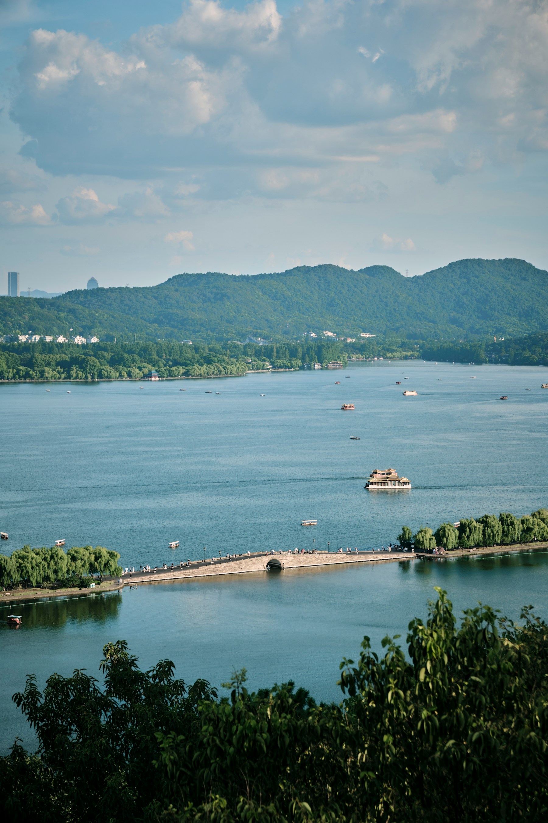 A quiet stone bridge and willow trees beside West Lake in Hangzhou