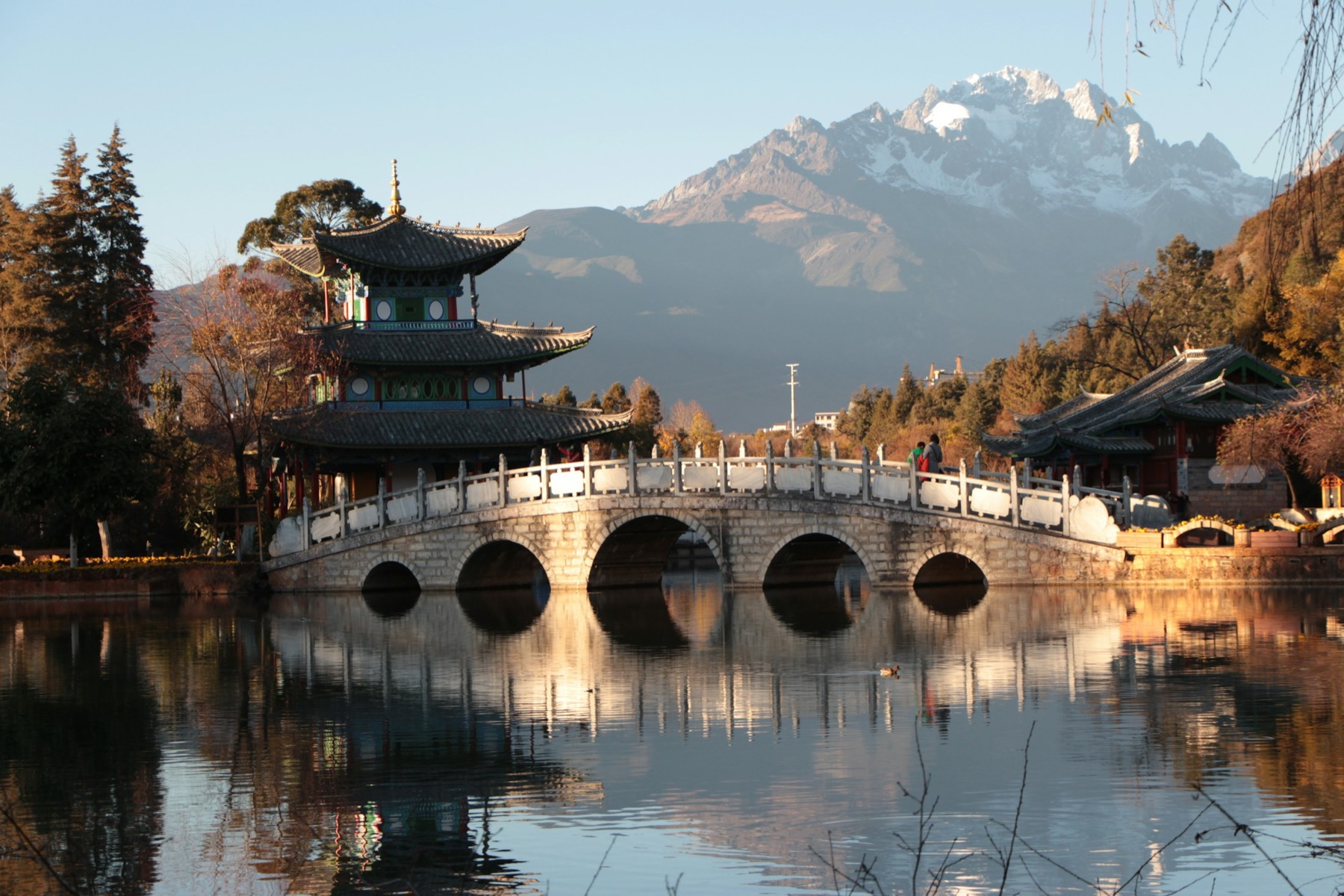 Steinbrücke und Pavillon am Black Dragon Pool mit Jade Dragon Snow Mountain hinter Lijiang
