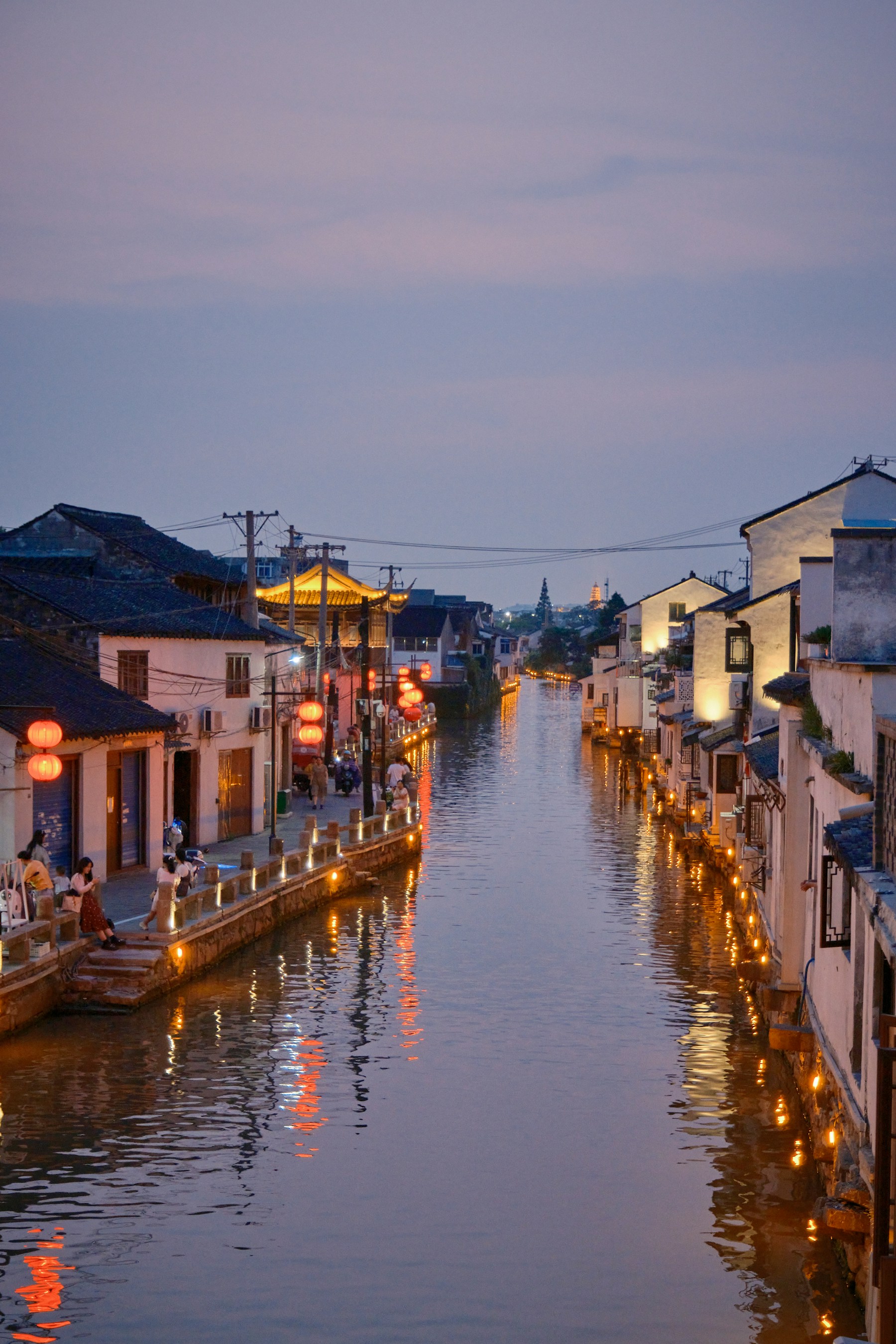 A narrow Suzhou canal lined with white-walled houses