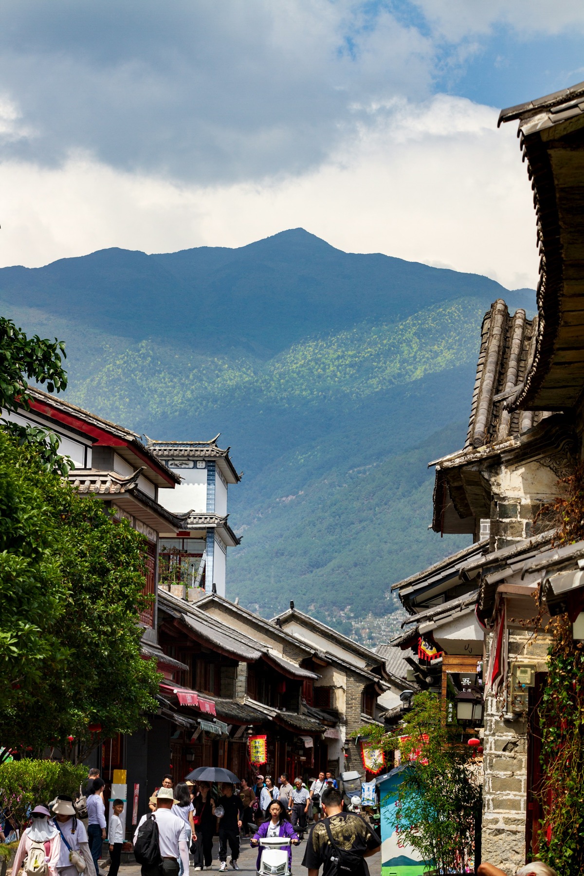 A Yunnan old-town street with mountains in the background