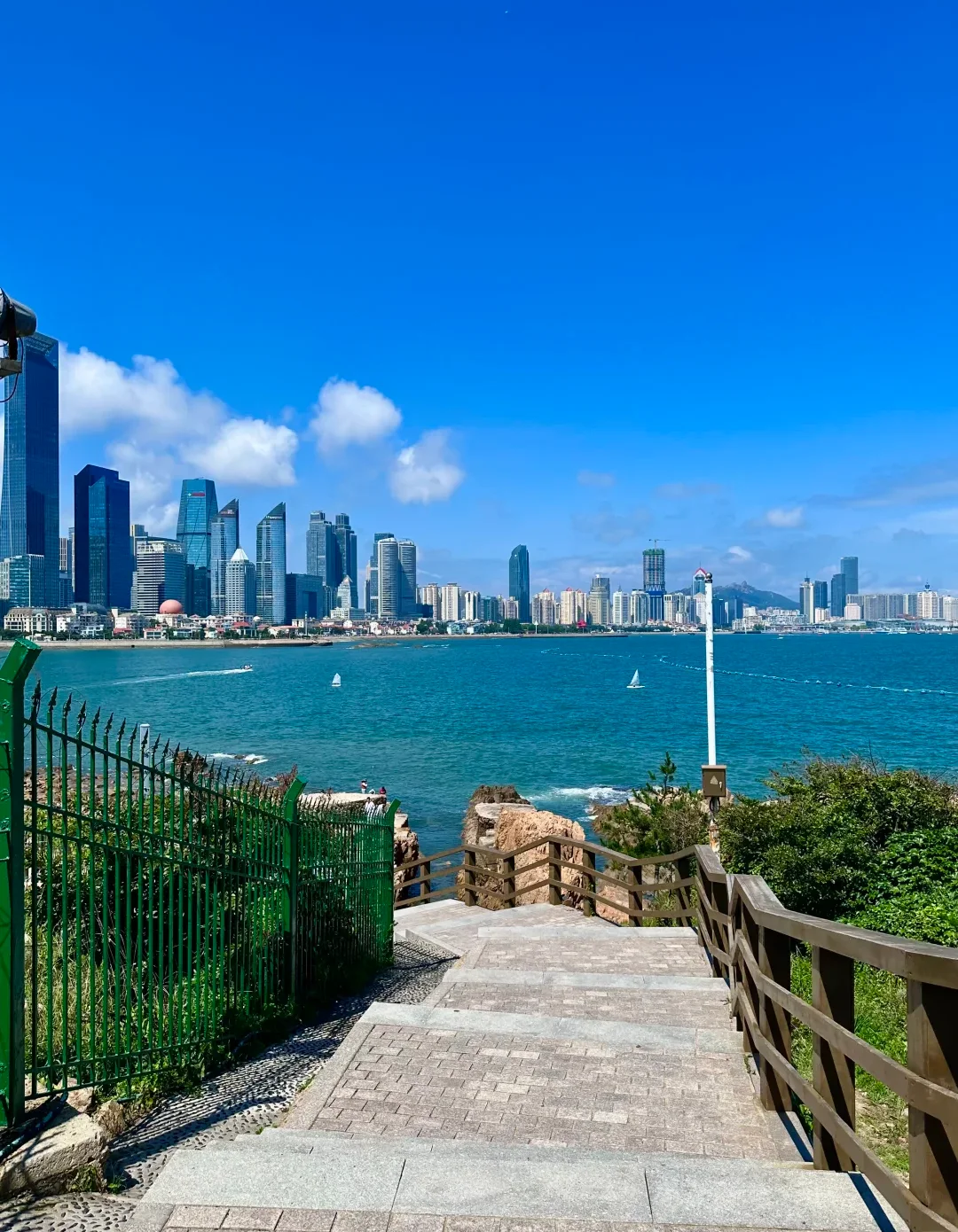 Qingdao skyline across the sea from a coastal walking path