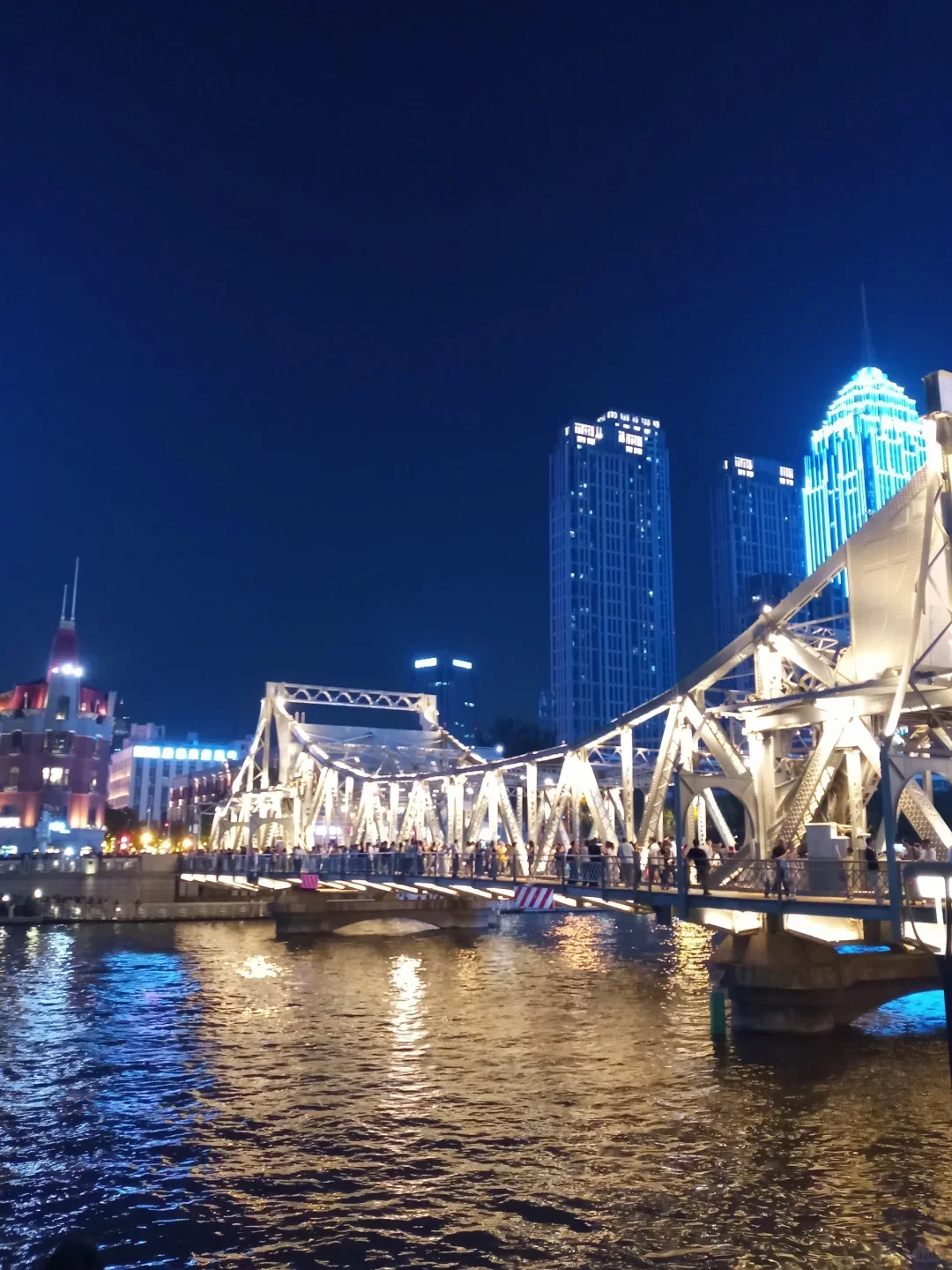 Illuminated bridge reflected in the Haihe River at night in Tianjin