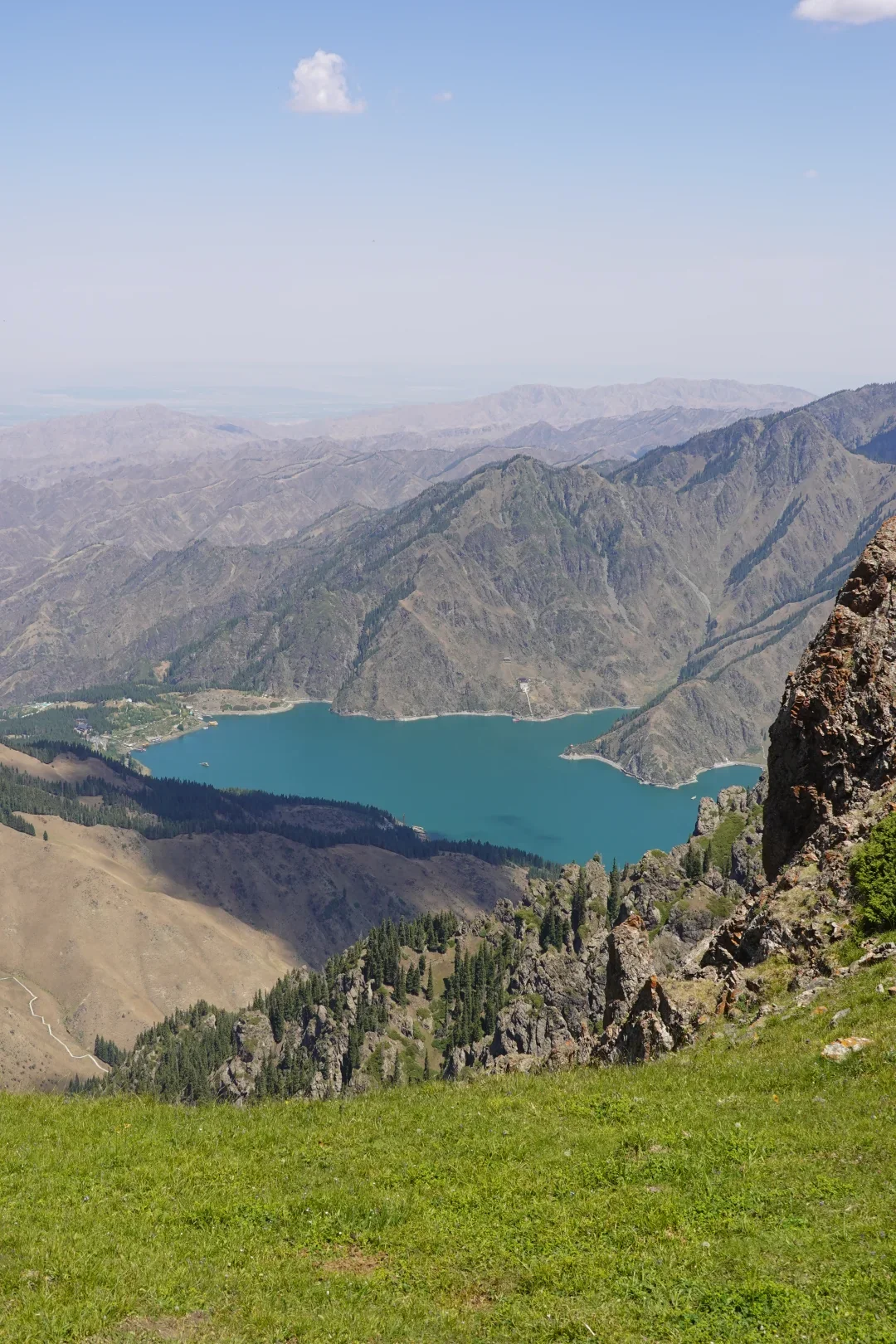 Tianchi lake surrounded by forested mountains and high Tianshan peaks